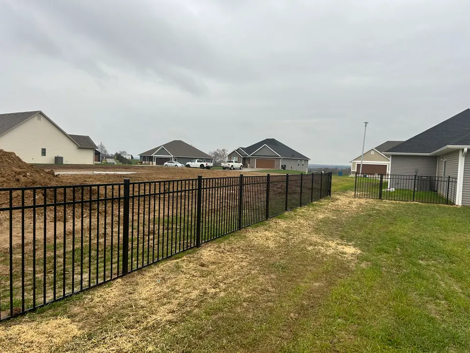 Black ornamental aluminum fence along a backyard in a new subdivision